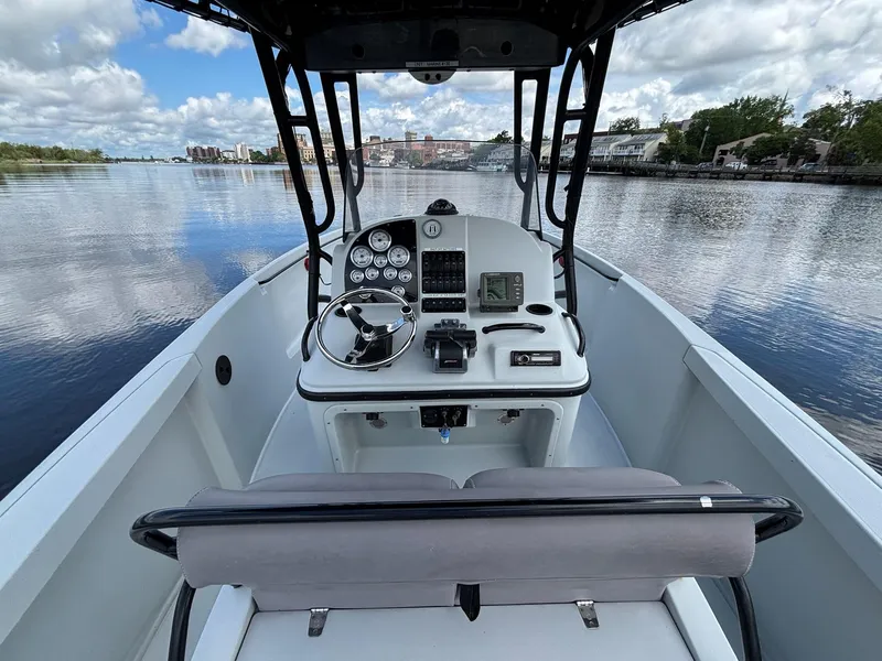 Slide: The Image of 2004 Baja 250 Sportfish boat dashboard with gauges, steering wheel, and serene water view. - 6