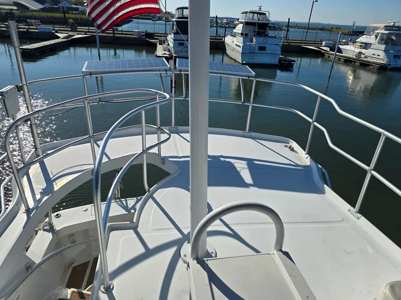 Slide: The Image of 1997 Mainship 350 Trawler interior with seating and helm, featuring a clear blue sky backdrop. - 11