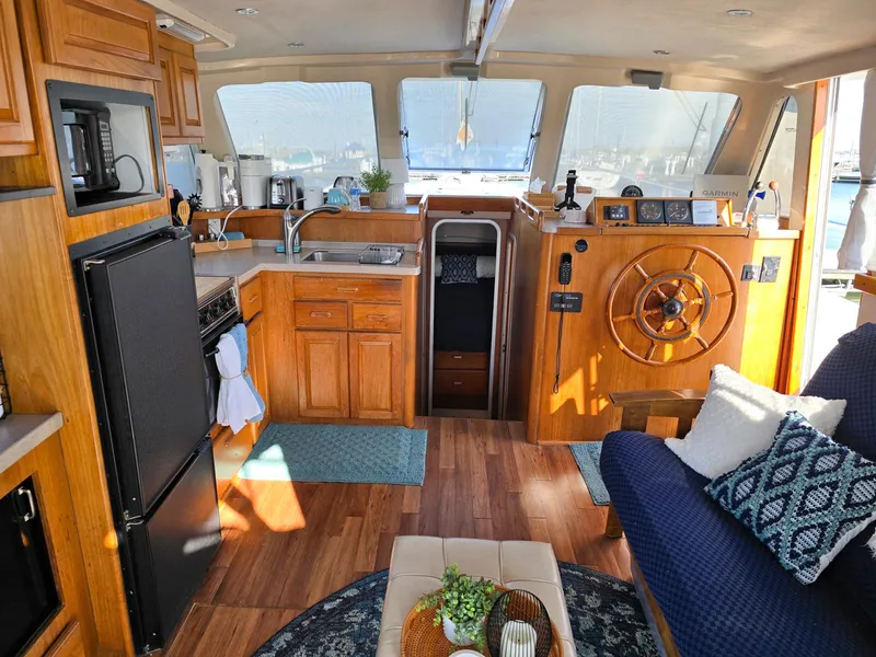 Slide: The Image of 1997 Mainship 350 Trawler docked at marina, view from upper deck with American flag. - 14