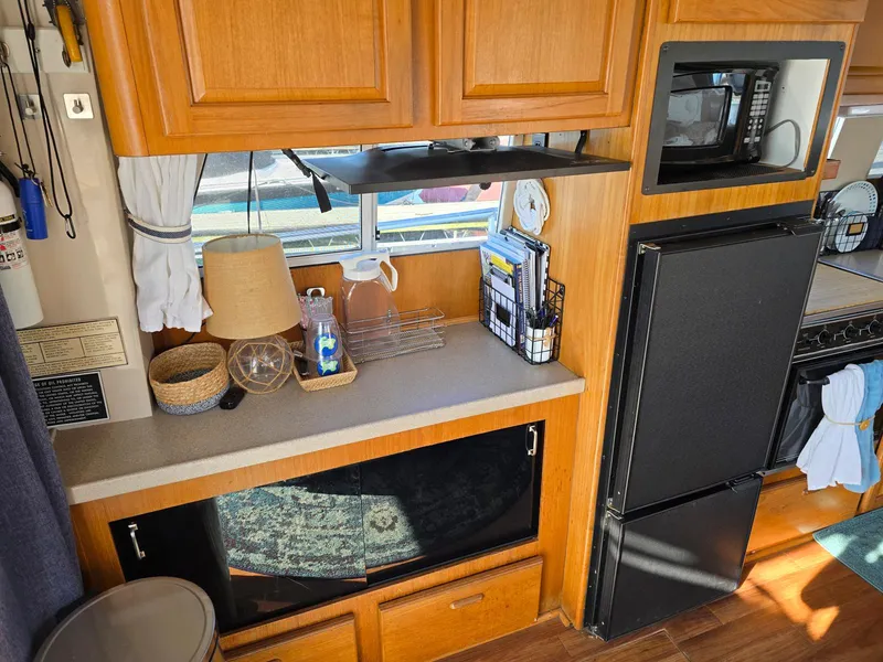 Slide: The Image of 1997 Mainship 350 Trawler with spacious deck and seating, docked at a marina. - 15