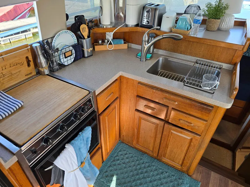 Slide: The Image of 1997 Mainship 350 Trawler deck with teak flooring and stainless steel railings. - 16