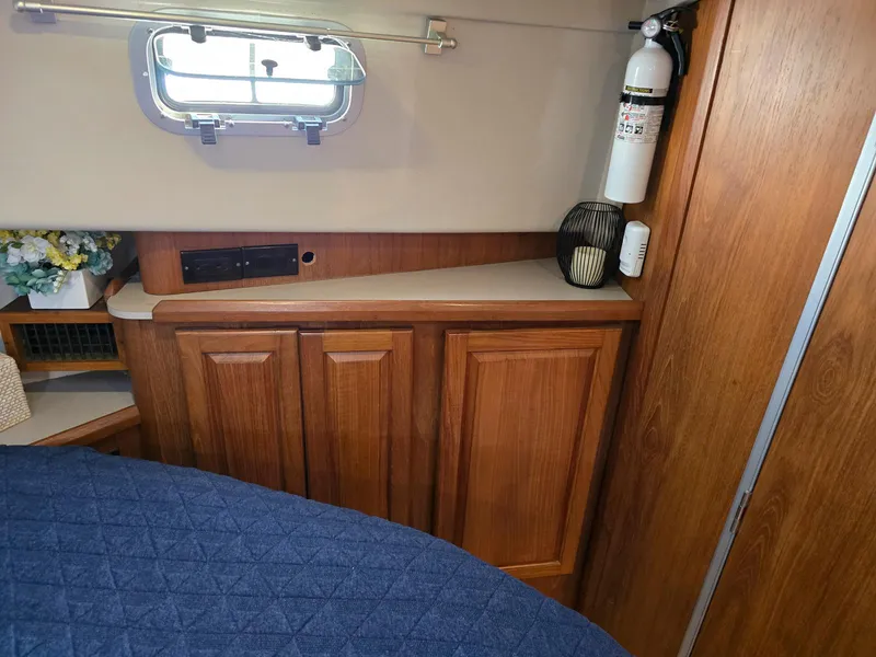 Slide: The Image of Interior of 1997 Mainship 350 Trawler with kitchen, seating, and marina view. - 22