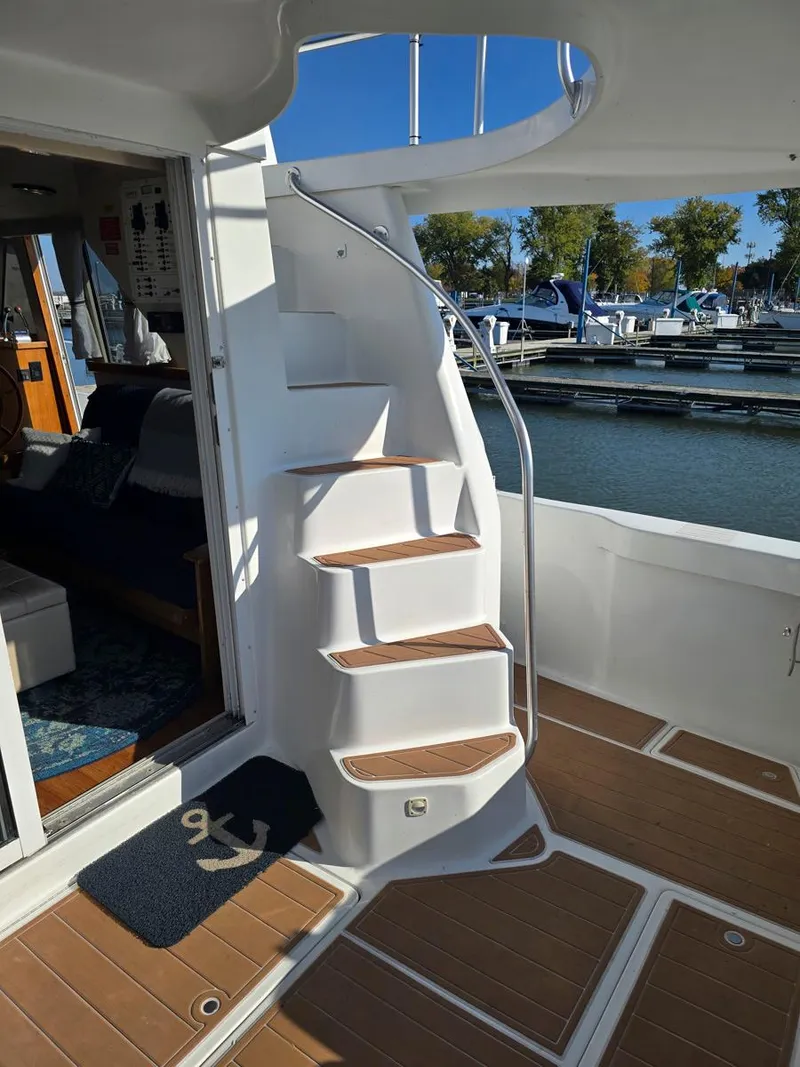 Slide: The Image of 1997 Mainship 350 Trawler with blue canopy, docked under clear sky. - 7
