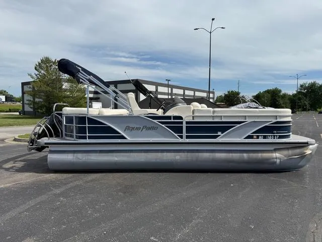 Slide: The Image of 2014 Godfrey Aqua Patio 22 pontoon boat parked in a lot, side view. - 1