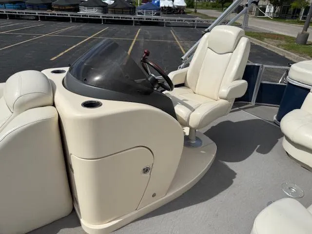 Slide: The Image of 2014 Godfrey 22 Aqua Patio boat helm with beige seating and steering wheel. - 13