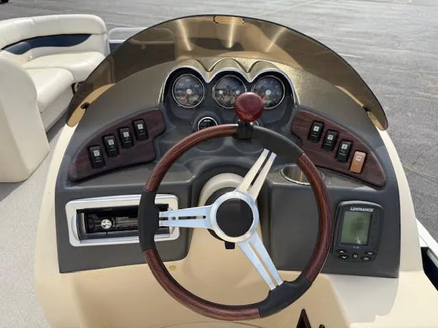 Slide: The Image of 2014 Godfrey 22 Aqua Patio dashboard with steering wheel and control panel. - 16