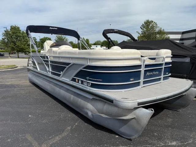 Slide: The Image of 2014 Godfrey 22 Aqua Patio pontoon boat with blue and white design, parked outdoors. - 2