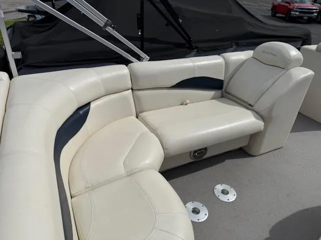 Slide: The Image of 2014 Godfrey 22 Aqua Patio boat interior with cream seating and cup holders. - 24