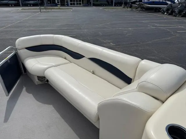 Slide: The Image of 2014 Godfrey 22 Aqua Patio boat with white and navy seating in a parking lot. - 25