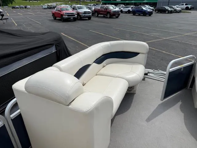 Slide: The Image of 2014 Godfrey 22 Aqua Patio boat with white seating in a parking lot. - 26