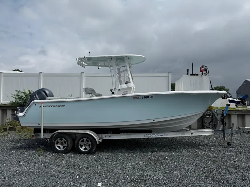 Slide: The Image of 2020 Sportsman Heritage 231 Center Console boat on a trailer, parked outdoors. - 0