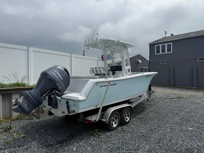 Slide: The Image of 2020 Sportsman Heritage 231 Center Console boat on trailer, parked on gravel. - 1