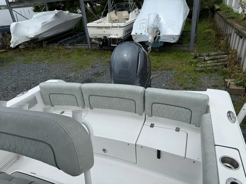 Slide: The Image of 2020 Sportsman Heritage 231 Center Console boat with cushioned seating and outboard motor. - 8