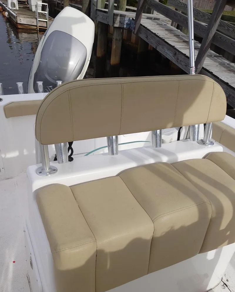 Slide: The Image of 2020 Cape Horn 22 OS boat with beige seating and rod holders, docked by wooden pier. - 3
