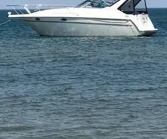 Slide: The Image of 1997 Maxum 3000 SCR boat anchored on calm water. - 1