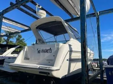 Slide: The Image of 1997 Maxum 3000 SCR boat named "No Ragrets" docked under a blue sky. - 2