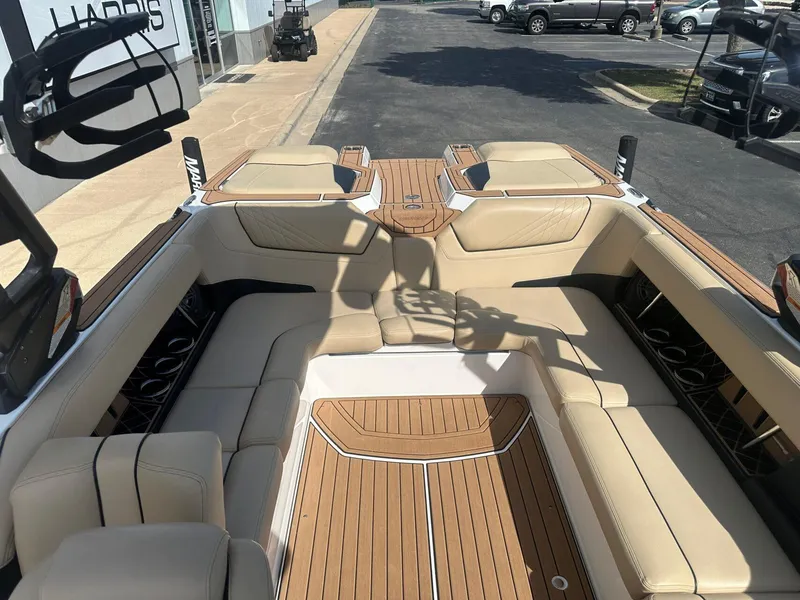 Slide: The Image of 2020 Nautique GS24 boat interior with beige seating and teak flooring. - 10