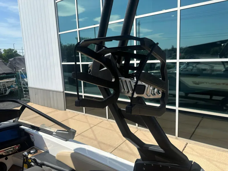 Slide: The Image of 2020 Nautique GS24 boat with a wakeboard rack, parked near a modern building. - 12