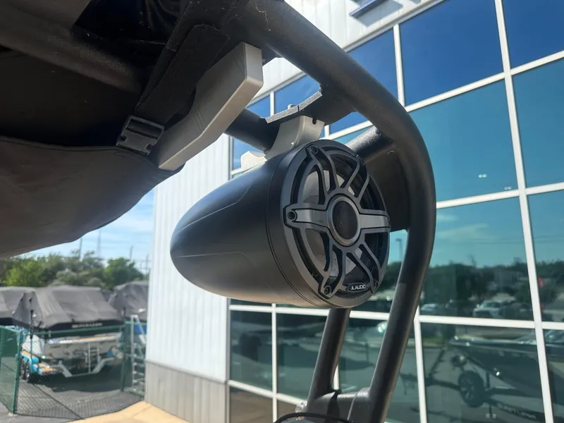 Slide: The Image of Speaker mounted on a 2020 Nautique GS24 boat, with a modern building in the background. - 13