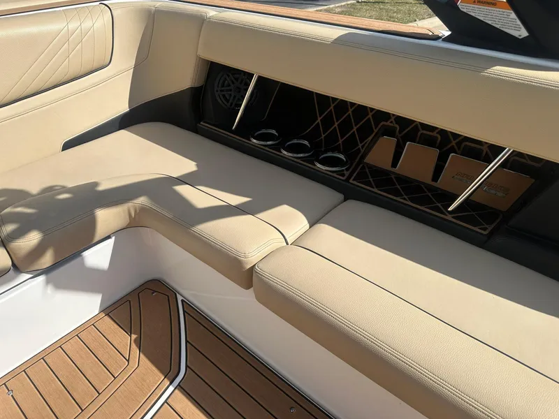 Slide: The Image of 2020 Nautique GS24 boat interior with beige seating and wood flooring. - 14