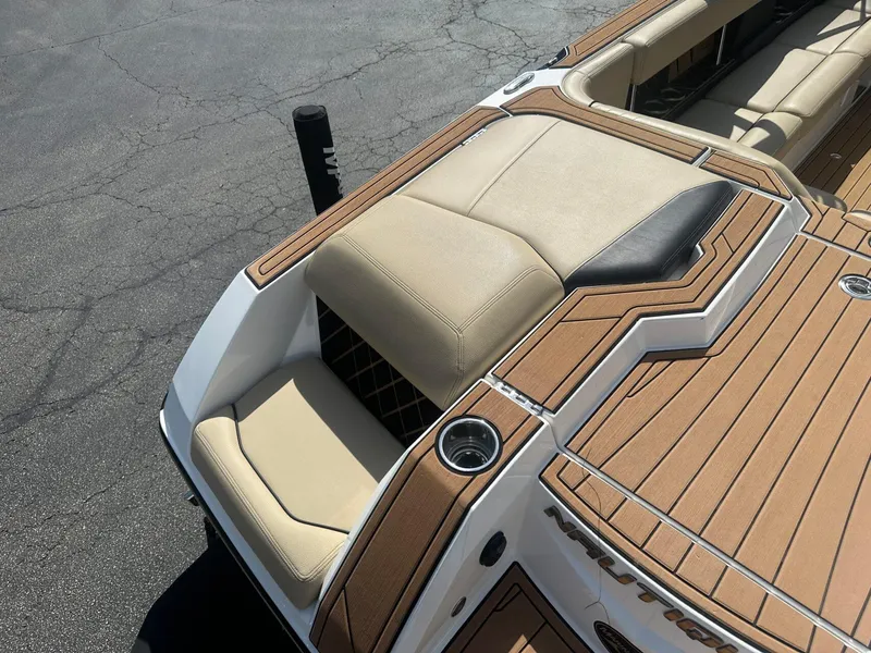 Slide: The Image of 2020 Nautique GS24 boat with tan seating and wood-style deck. - 15