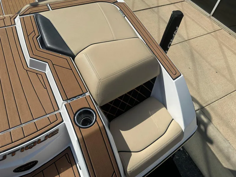 Slide: The Image of 2020 Nautique GS24 boat seating with tan upholstery and wood accents. - 16