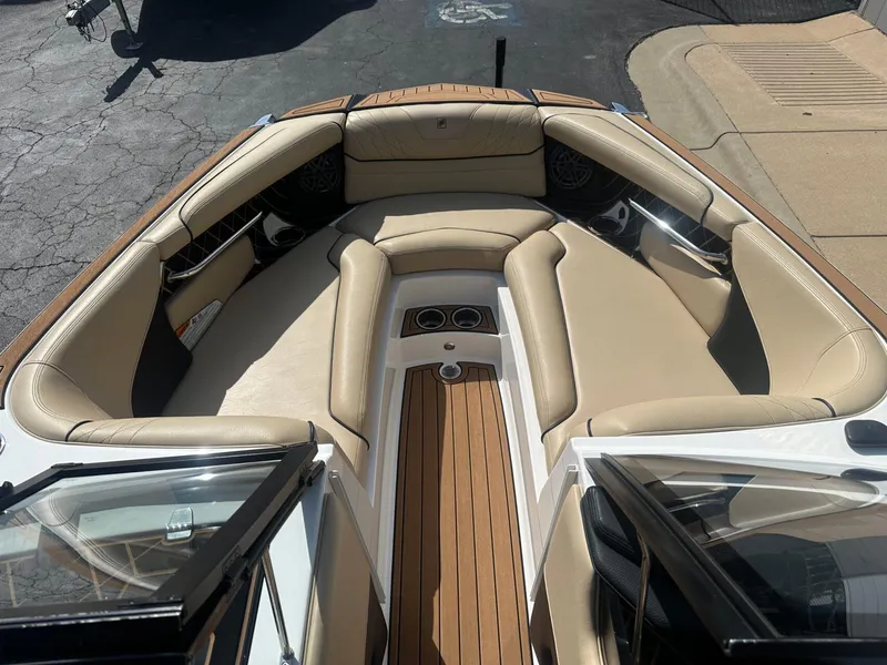 Slide: The Image of 2020 Nautique GS24 boat interior with beige seating and wood accents. - 4