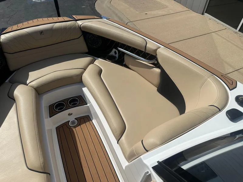 Slide: The Image of 2020 Nautique GS24 boat interior with beige seating and wood accents. - 5