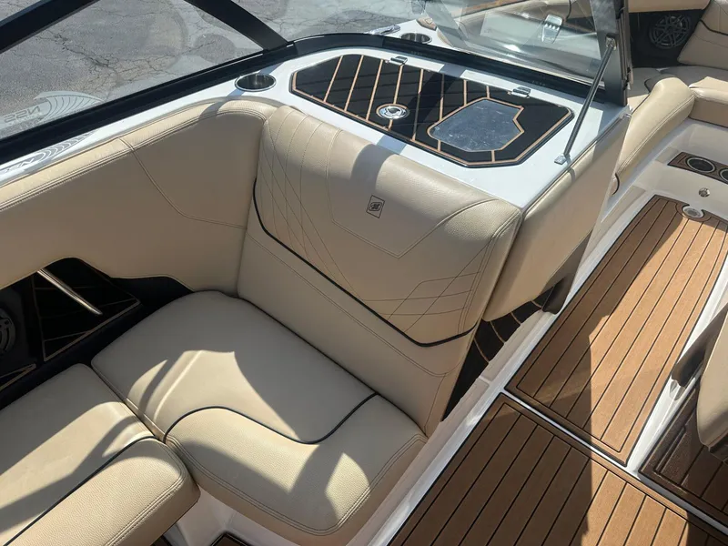 Slide: The Image of 2020 Nautique GS24 boat interior with beige seating and teak-style flooring. - 6