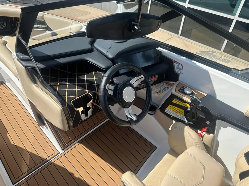 Slide: The Image of 2020 Nautique GS24 boat interior with steering wheel and dashboard, featuring beige and black accents. - 7