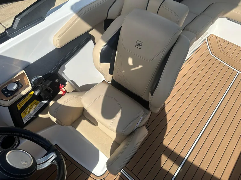 Slide: The Image of 2020 Nautique GS24 boat interior with beige seating and wood-style flooring. - 8