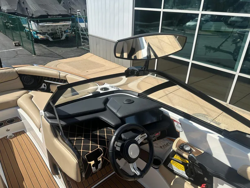Slide: The Image of 2020 Nautique GS24 boat interior with steering wheel and dashboard, featuring beige seating. - 9