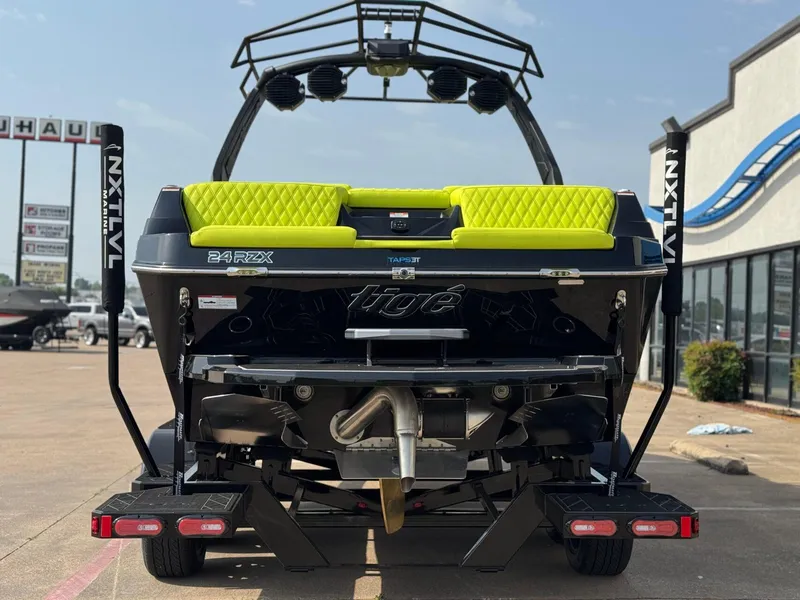 Slide: The Image of 2025 Tigé 24RZX boat with lime green seating, displayed at a dealership. - 4