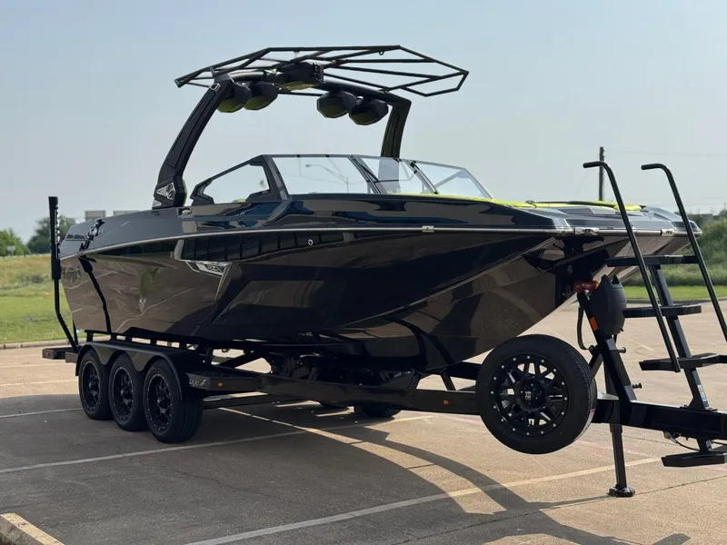 Slide: The Image of 2025 Tigé 24RZX boat on trailer, sleek black design, parked outdoors. - 6
