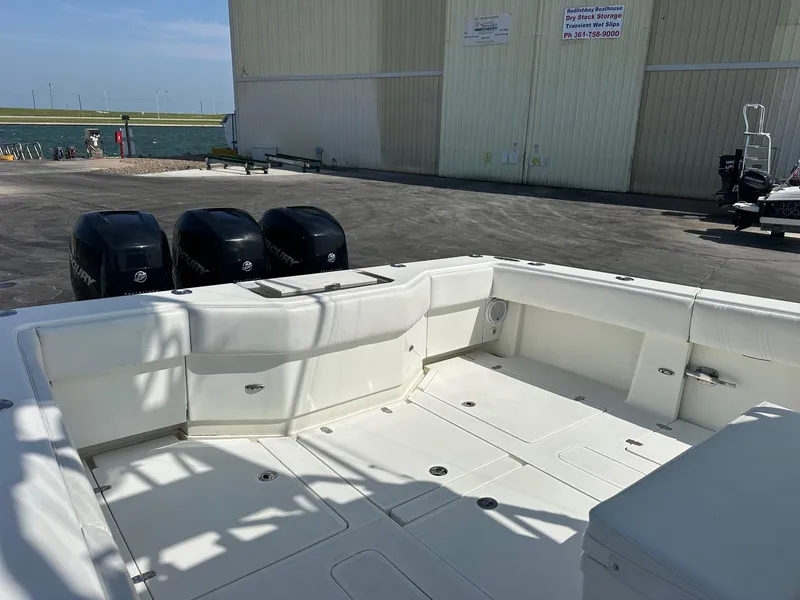 Slide: The Image of 2013 SeaVee 390B boat with triple outboard engines, docked near a waterfront building. - 12