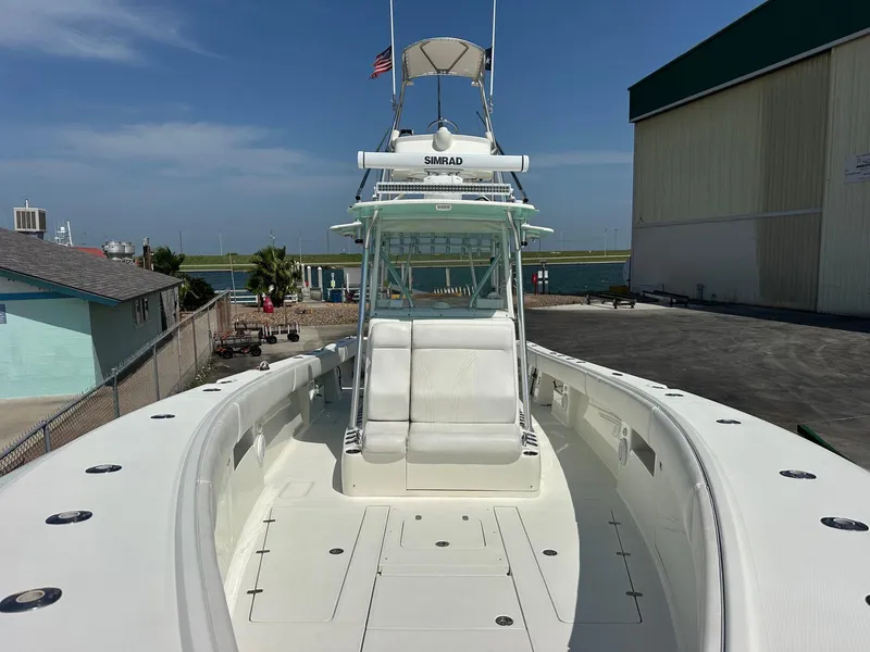 Slide: The Image of 2013 SeaVee 390B boat docked, featuring spacious deck and helm, with clear skies above. - 17