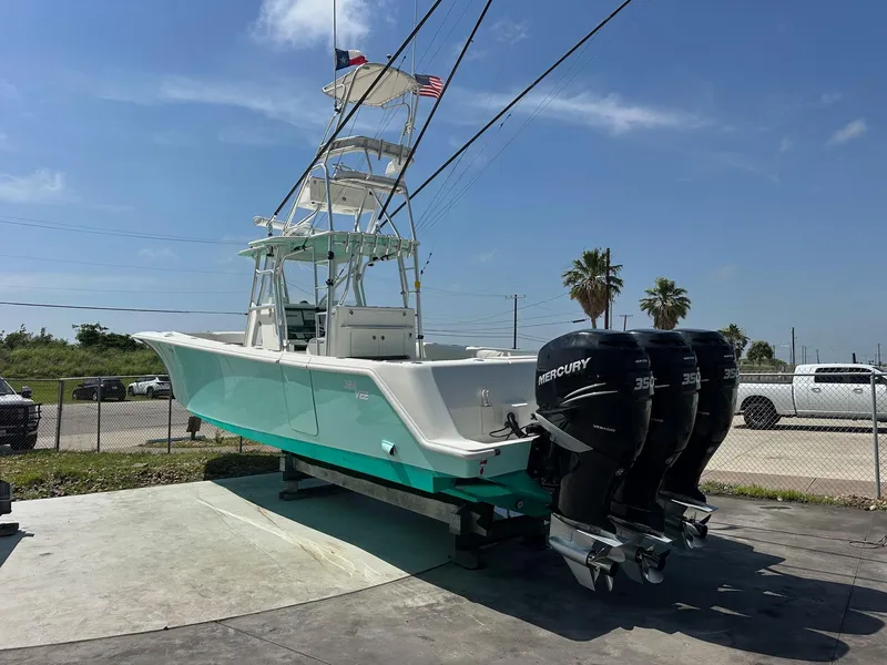 Slide: The Image of 2013 SeaVee 390B boat with triple Mercury engines, docked under a clear blue sky. - 3