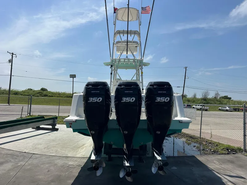 Slide: The Image of 2013 SeaVee 390B boat with triple 350 horsepower engines, docked under a clear sky. - 4