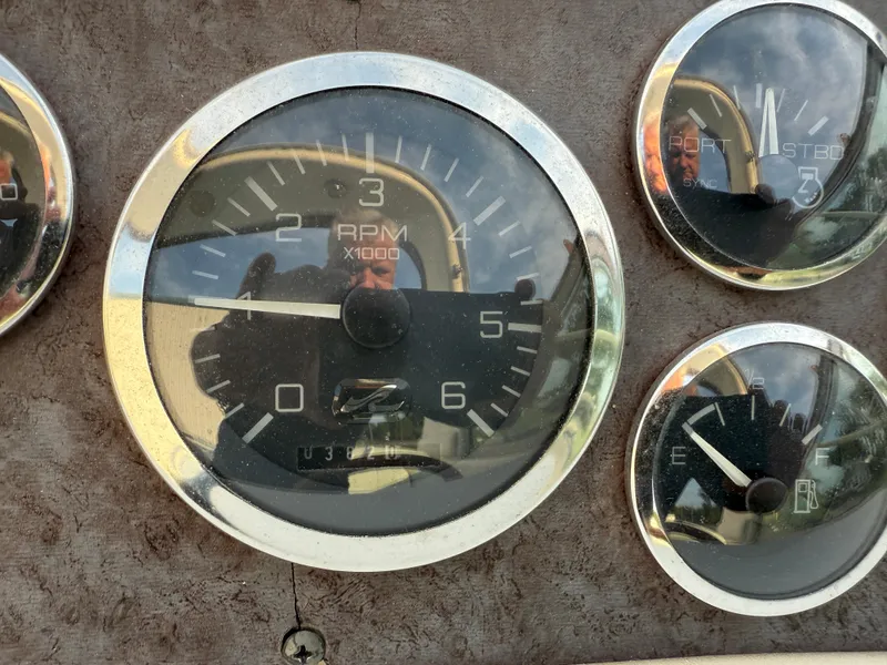 Slide: The Image of Close-up of 1997 Sea Ray 290 Sundancer boat dashboard gauges, featuring RPM and fuel indicators. - 17