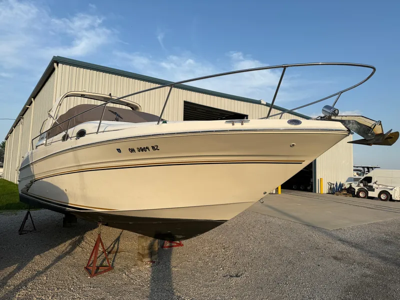 Slide: The Image of 1997 Sea Ray 290 Sundancer boat on stands outside a large storage building. - 2
