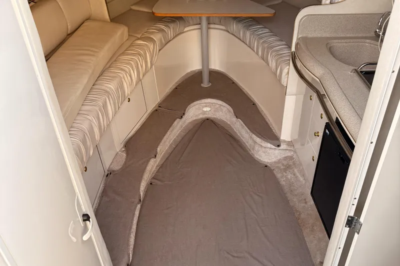 Slide: The Image of 1997 Sea Ray 290 Sundancer cabin interior with seating, table, and kitchenette. - 23