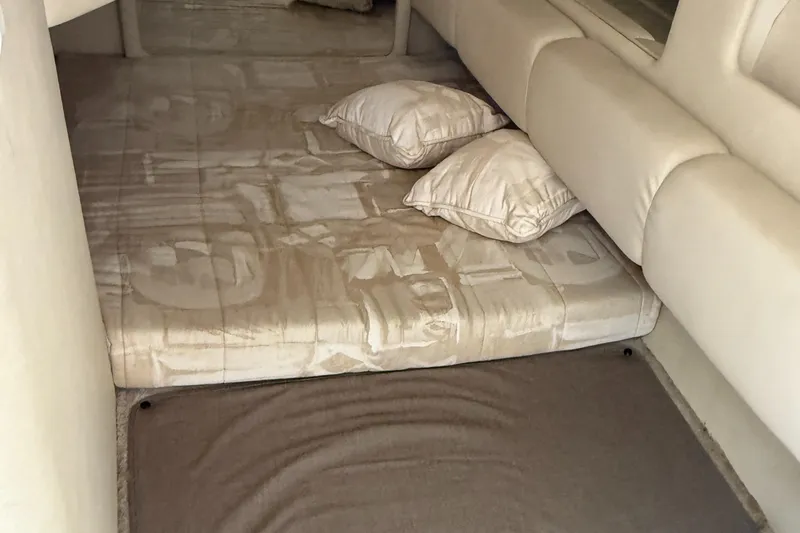 Slide: The Image of 1997 Sea Ray 290 Sundancer cabin interior with bed and pillows. - 25