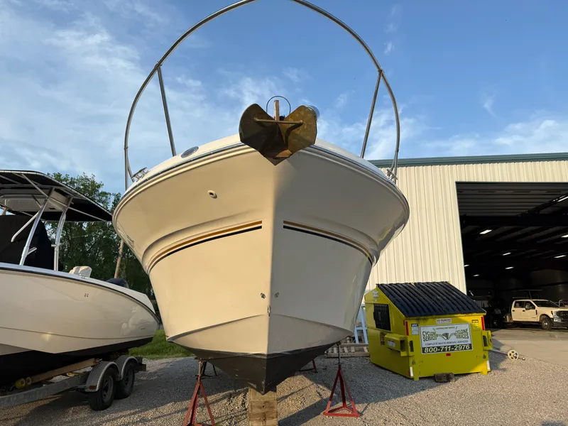 Slide: The Image of 1997 Sea Ray 290 Sundancer boat on stands, front view, near a storage facility. - 4