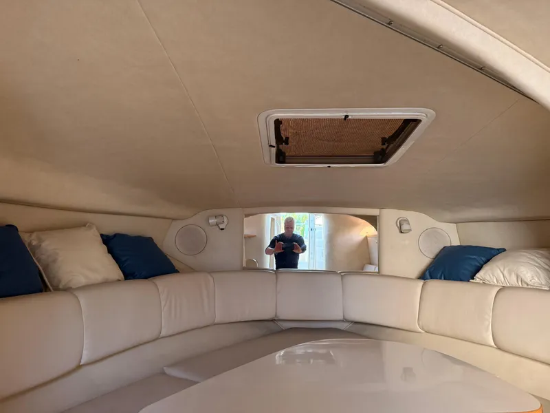 Slide: The Image of Interior of 1997 Sea Ray 290 Sundancer with white seating and blue cushions. - 6