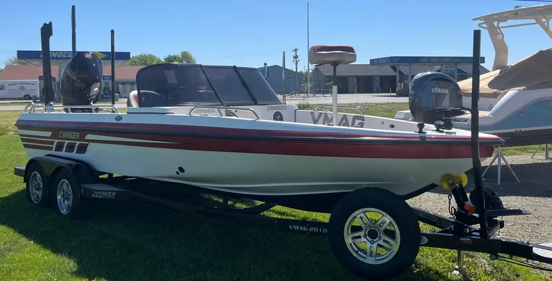 Slide: The Image of 2022 Charger VMAG 2010 boat on trailer, parked outdoors, sunny day. - 12