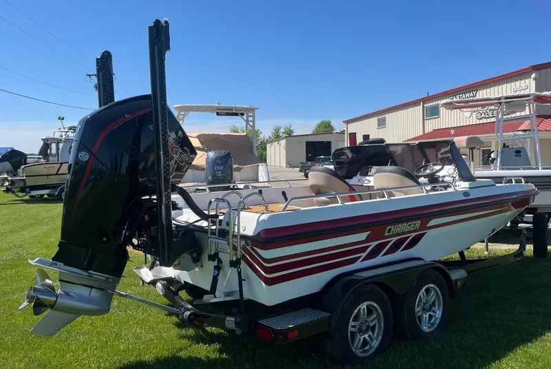 Slide: The Image of 2022 Charger VMAG 2010 boat on trailer, parked on grass near dealership. - 3