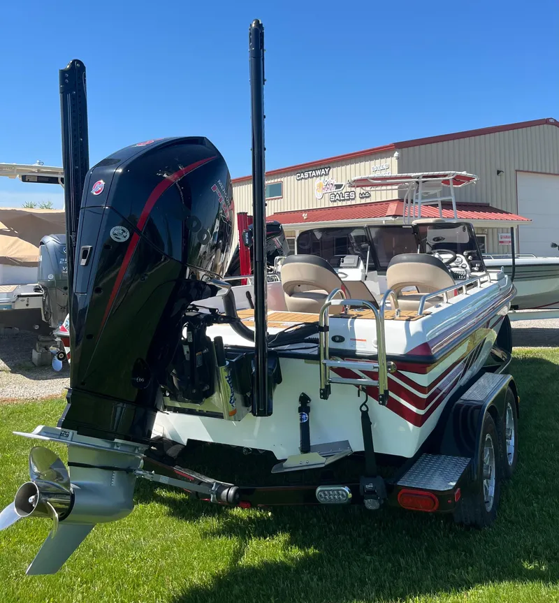 Slide: The Image of 2022 Charger VMAG 2010 boat with powerful outboard motor, parked on grass. - 6