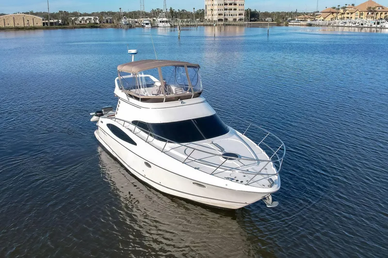 Slide: The Image of 2003 Regal Commodore 3880 yacht on calm water, showcasing sleek design and luxury features. - 2