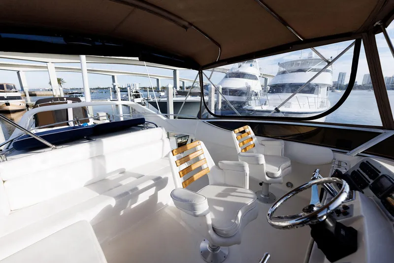 Slide: The Image of 2003 Regal Commodore 3880 yacht interior with steering wheel and seating, docked at marina. - 23