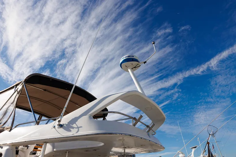Slide: The Image of 2003 Regal Commodore 3880 yacht under a vibrant blue sky with wispy clouds. - 25